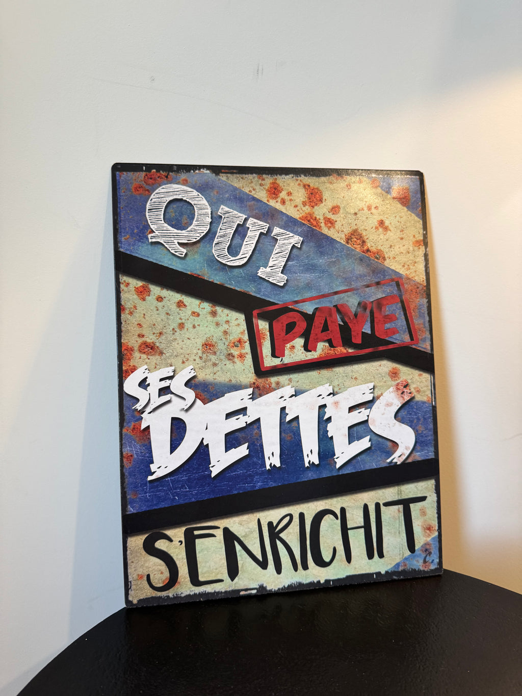 Plaque métallique rétro « Qui paye ses dettes s'enrichit » (33 × 25 cm)